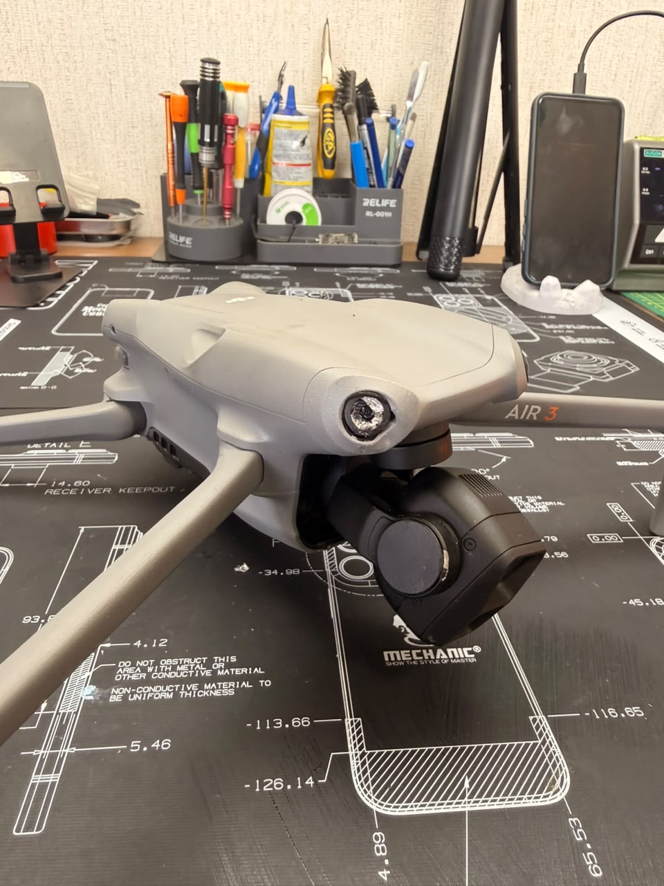 DJI Air 3 en la mesa de trabajo de TECDJI PERÚ con el eje del gimbal dañado antes de su reparación