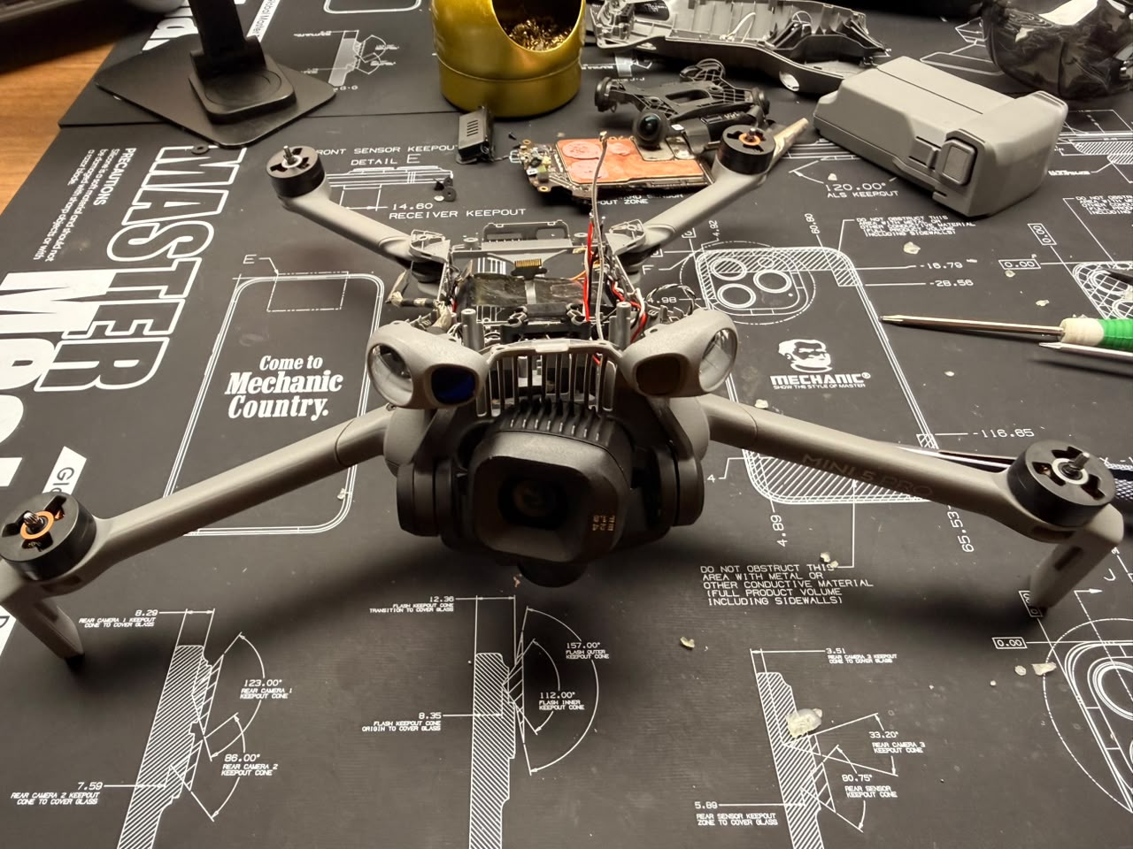 DJI Mini 5 Pro desarmado en el taller de TECDJI PERÚ durante una recuperación tras impacto, con la placa principal fuera del equipo